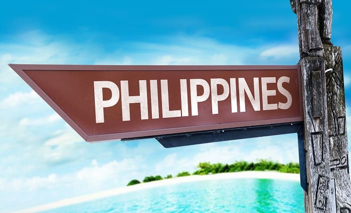 Philippines wooden sign with a beach on background